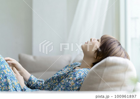 ソファでくつろぐ若い女性 ソファでくつろぐ若い女性 100961897