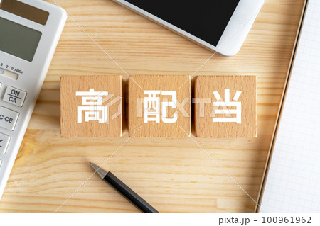 高配当と書かれたブロックが置かれた机 100961962