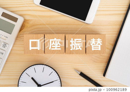 口座振替と書かれたブロック、電卓、スマホ、ノート、時計 100962189