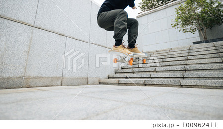 Skateboarder skateboarding in modern city 100962411