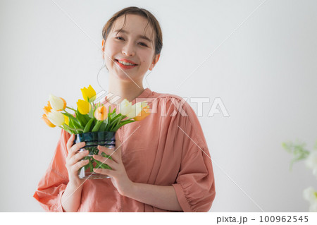 チューリップの花瓶を持つ女性 100962545