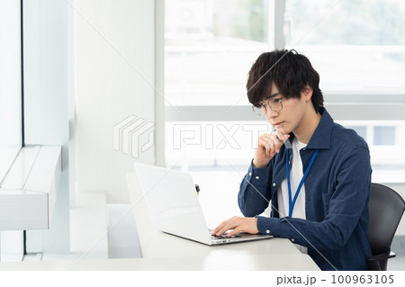 オフィスでパソコンに向って考えるビジネスマン 100963105