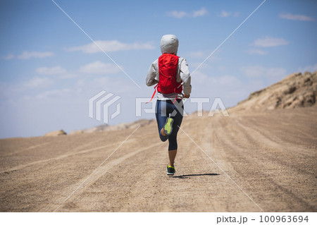 Fitness woman trail runner cross country running  on desert 100963694