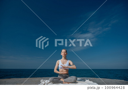 Yoga practice and meditation in nature. Woman practicing near Black sea. 100964428