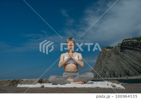 Yoga practice and meditation in nature. Woman practicing near Black sea. Yoga practice and meditation in nature. Woman practicing near Black sea. 100964535