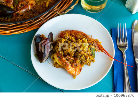 Delicious traditional Valencian seafood paella - savory rice dish with shrimps and clams Delicious traditional Valencian seafood paella - savory rice dish with shrimps and clams 100965376