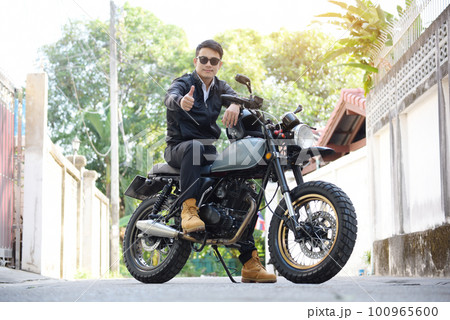 Asian man motorbike in black leather jacket travel rider trip. Handsome Men wear sunglass outdoor lifestyle freedom rider. Men trendy hipster cool person. Young asian man hobby ride with motor bike 100965600
