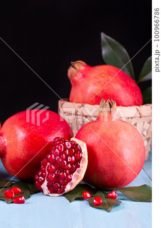 Ripe pomegranate fruits on the wooden background Ripe pomegranate fruits on the wooden background 100966786