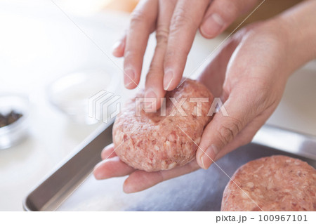 ハンバーグを成型する女性の手元 100967101
