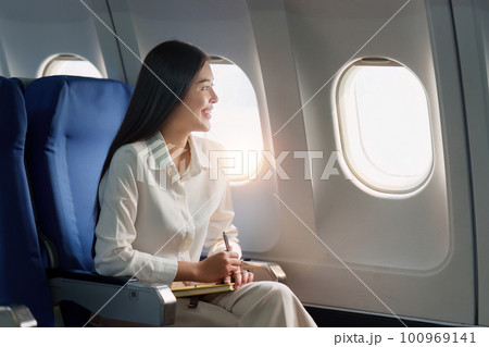 Beautiful Asian businesswoman working with laptop in aeroplane. working, travel, business concept Beautiful Asian businesswoman working with laptop in aeroplane. working, travel, business concept 100969141