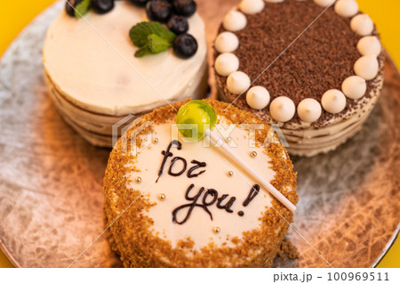 Three bento cakes with different designs on a yellow background. Three bento cakes with different designs on a yellow background. 100969511