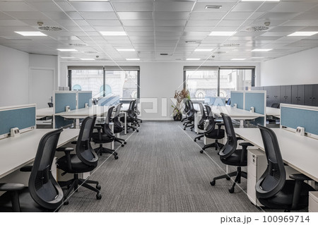 Soothing gray office with long tables and chairs before the opening of a driving school in anticipation of students. Concept of school and advanced training center Soothing gray office with long tables and chairs before the opening of a driving school in anticipation of students. Concept of school and advanced training center 100969714