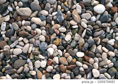 Smooth round wet pebbles texture background. Pebble sea beach close-up. 100970685