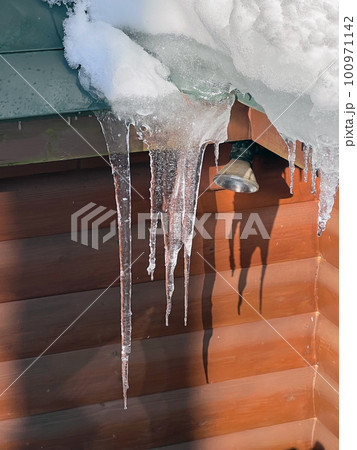 ログハウスの屋根に積もった雪と氷柱 ログハウスの屋根に積もった雪と氷柱 100971142