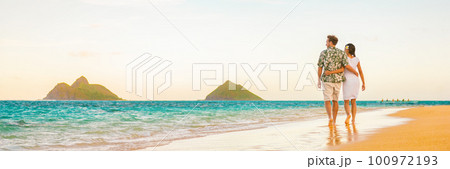 Couple walking on beach sunset vacation panoramic hawaii travel. Woman and man relaxing on tourist holiday in Lanikai, Oahu, Hawaii banner. 100972193
