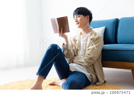 自宅でくつろぐ若い男性 100973471