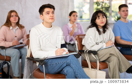 Young male student diligently attending lesson in college 100973834