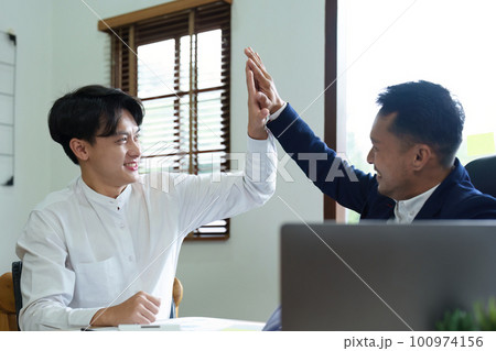 Portrait of two young Asian entrepreneurs congratulating them with smiling faces after successful investment negotiations. Portrait of two young Asian entrepreneurs congratulating them with smiling faces after successful investment negotiations. 100974156