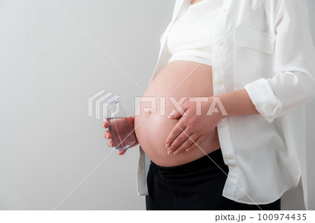 Pregnant woman applying cosmetic oil on her belly for healing stretch marks and skin elasticity 100974435