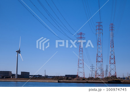 青空の中の3本の送電鉄塔と風力発電の風車、カーボンニュートラルのイメージ 100974745