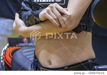 胸の前で腕を組むセクシーなお臍を出した女性 100975019