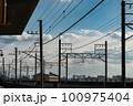 鉄道の架線の向こうに広がる雲の浮かぶ青空 100975404