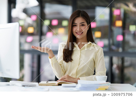 Beautiful Asian Banker or Accountant makes financial report and tax, analyzes profits. Accountant checks status of financial 100975706