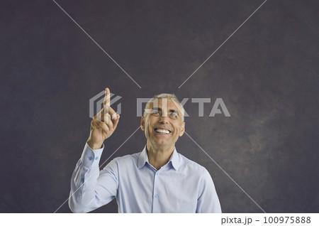 Happy senior man has idea or presents incredible proposal by pointing his finger at copy space. Happy senior man has idea or presents incredible proposal by pointing his finger at copy space. 100975888