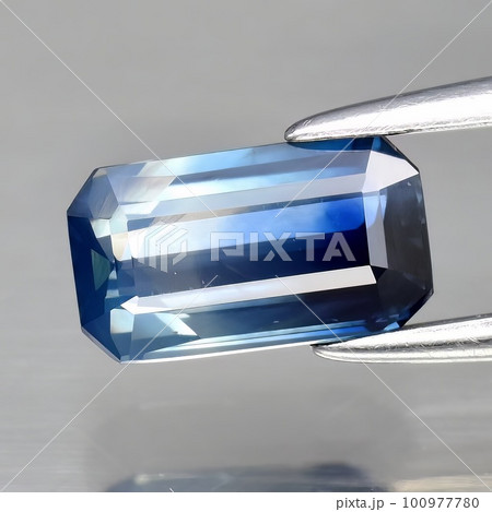 Natural gemstone blue sapphire on gray background 100977780