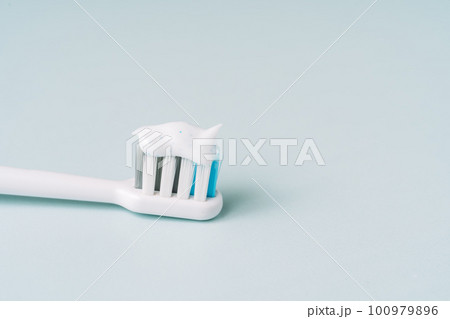 Toothbrush with toothpaste on blue background Toothbrush with toothpaste on blue background 100979896
