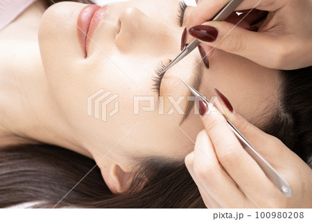 まつ毛エクステの施術を受ける女性のアップ まつ毛エクステの施術を受ける女性のアップ 100980208