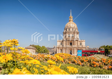 View of Les Invalides with spring flowers and tour bus in Paris, France 100981623