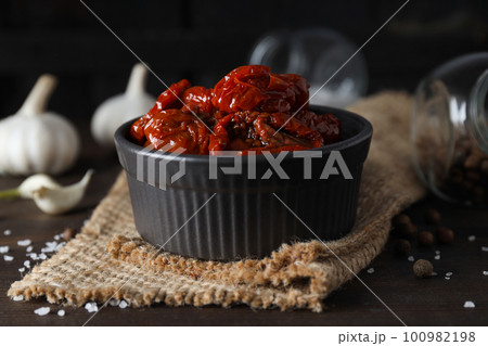 Concept of tasty food - delicious dried tomato Concept of tasty food - delicious dried tomato 100982198