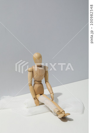 Concept of injury with wooden puppet with bandage 100982548