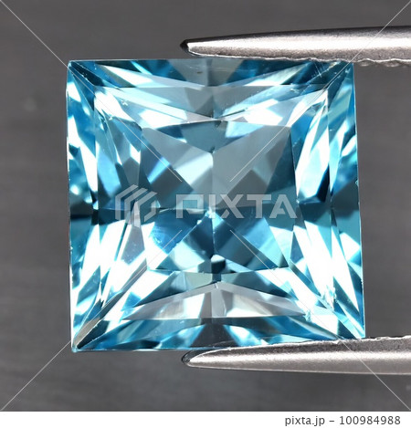 Natural blue topaz gemstone on gray background 100984988