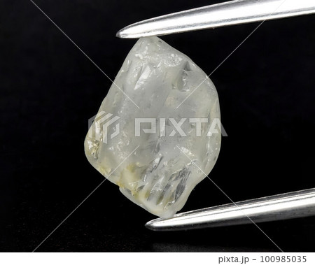 Natural gemstone yellow sapphire on a gray background. Raw sapphire crystal 100985035