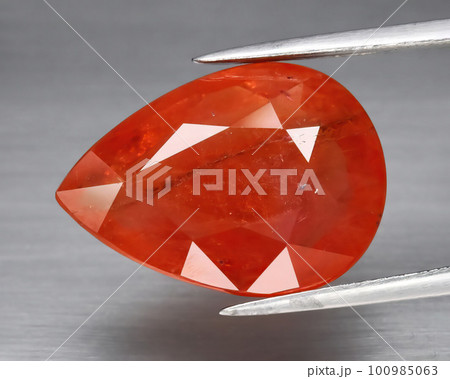 Natural gemstone orange Padparadscha sapphire on gray background Natural gemstone orange Padparadscha sapphire on gray background 100985063
