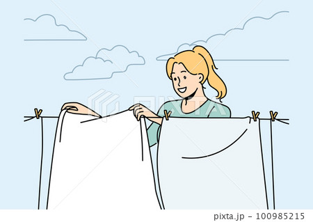 Smiling woman hanging clothes to dry Smiling woman hanging clothes to dry 100985215