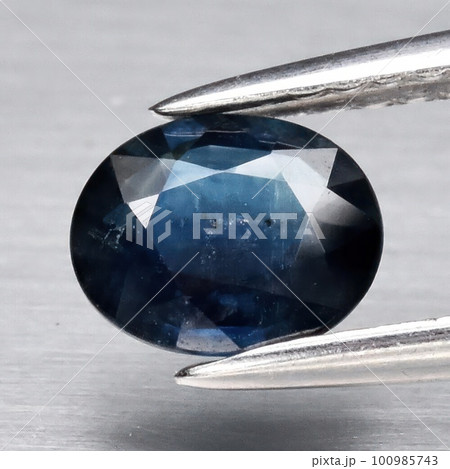 Natural gemstone blue sapphire on gray background Natural gemstone blue sapphire on gray background 100985743
