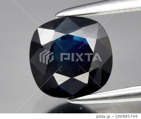 Natural gemstone blue sapphire on gray background 100985744