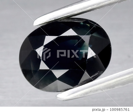 Natural gemstone blue sapphire on gray background 100985761