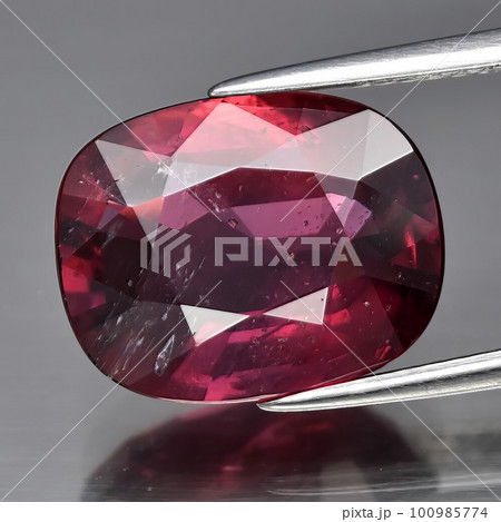 Natural gemstone red ruby on gray background 100985774