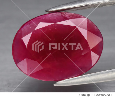Natural gemstone red ruby on gray background 100985781