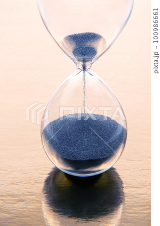hourglass on a golden background. time and minute measurement hourglass on a golden background. time and minute measurement 100986661