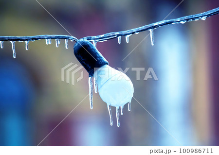 icicles on frozen street lighting lamps. winter weather season. street interior details. icicles on frozen street lighting lamps. winter weather season. street interior details. 100986711