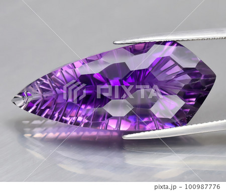Natural gemstone purple amethyst on gray background 100987776