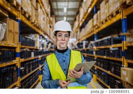 Warehouse female worker checking up stuff in a warehouse. 100988091