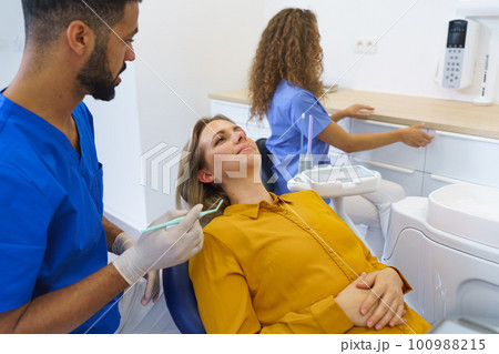 Dental examination of young woman at dental clinic. 100988215