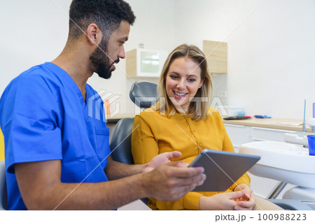 Young woman having consultation with multiracial dentist. 100988223