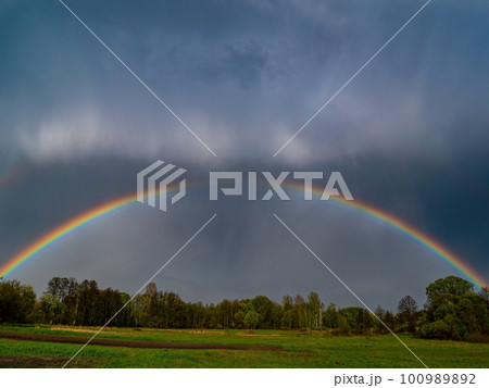 Rainbow with rain clouds in the sky. Rainbow with rain clouds in the sky. 100989892